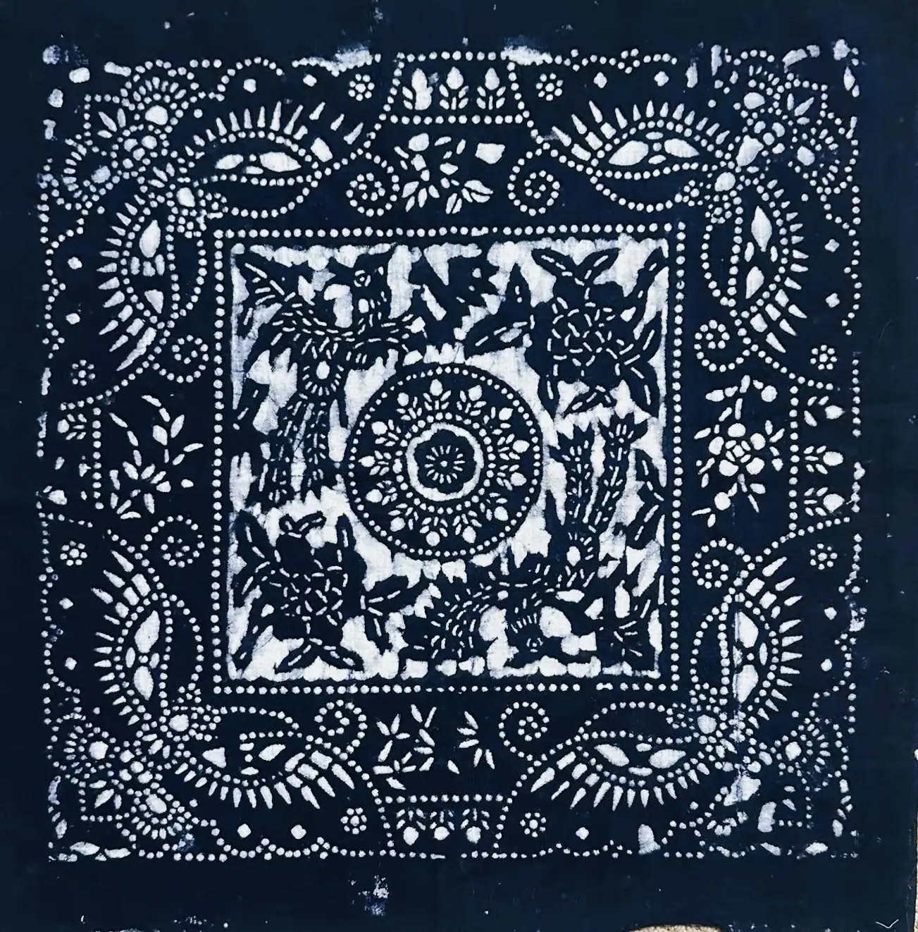 Indigo study fragment with dense white resist motifs and a framed central composition.