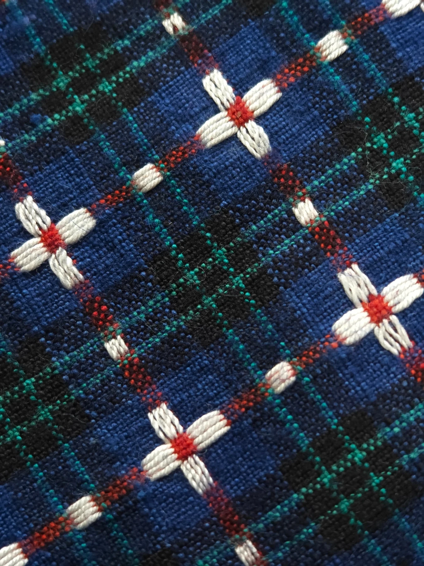 Close view of the woven four-petal tiaohua motif and coloured plaid structure.
